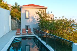 een huis met een balkon en een zwembad bij Villa Marinkica in Brela
