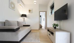 uma sala de estar com um sofá e uma televisão de ecrã plano em Cozy one bedroom apartment in Tivat em Tivat
