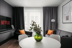 uma sala de estar com uma mesa branca com um vaso de flores em Dlouha Apartments Old Town Prague em Praga