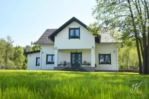 a white house with a green lawn at Kádárház in Vlăhiţa