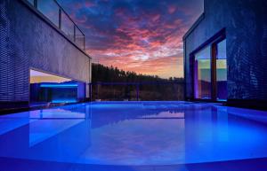 ein Haus mit einem Pool mit Sonnenuntergang in der Unterkunft Landhotel Sternwirt - Das Wellnesshotel zwischen Nürnberg und Amberg in Högen
