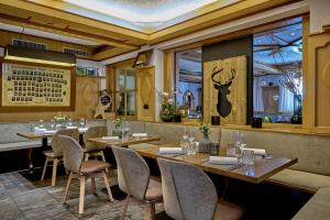 a restaurant with wooden tables and chairs and windows at Landhotel Sternwirt - Das Wellnesshotel zwischen Nürnberg und Amberg in Högen
