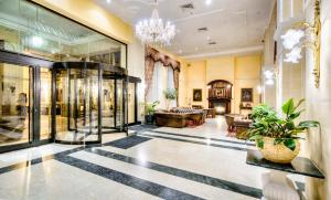 a lobby with a chandelier and a store at AX The Victoria Hotel in Sliema