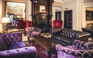 a living room with a leather couch and chairs at AX The Victoria Hotel in Sliema