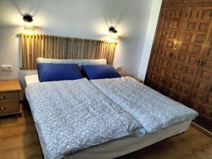 ein Schlafzimmer mit einem Bett mit blauer Bettwäsche und einer Tür in der Unterkunft Tabaira in Moraira