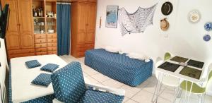 ロケタス・デ・マルにあるEstudio Frente Al Marのリビングルーム(青と白の椅子、テーブル付)