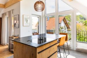 a kitchen with a island with a black counter top at Design Wohnung `Eiche´ auf dem Bodanrück in Radolfzell am Bodensee