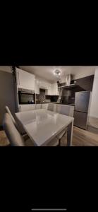 cocina con mesa blanca y sillas en Modern 2 bed apartment & free parking en Canterbury