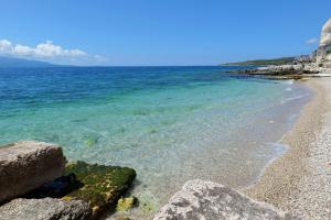 una playa con rocas y el océano en un día soleado en Oceanic Overview Suites en Sarandë