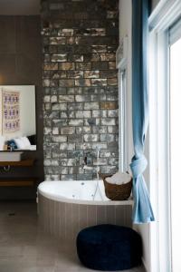 a bath tub in a room with a brick wall at Spa Eilat Mountain Lodge in Eilat