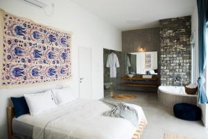 a bedroom with a bed and a bathroom with a tub at Spa Eilat Mountain Lodge in Eilat +73 photos