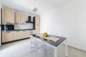 a kitchen with a table and chairs in a room at Quintino Apartments Pool in Torre Lapillo
