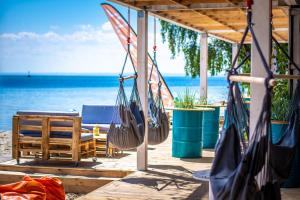 a group of hammocks hanging from a porch overlooking the ocean at Przyczepa FOREMKI w Molo Surf in Jastarnia