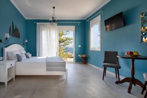 1 dormitorio con paredes azules, 1 cama y 1 mesa en Evi Boutique Rooms en Galatás