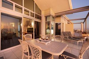 a dining table on a balcony with a view of the city at Seaside Village Penthouse F23 by HostAgents in Cape Town