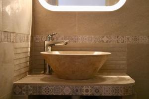a bathroom with a bowl sink and a light at Studio au cœur du village provençale de Riez. Dans le Verdon. in Riez