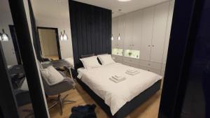 a bedroom with a bed and a desk and a chair at MADOST APART MOKOTÓW 54 m2 Airport Chopin & Buisness in Warsaw