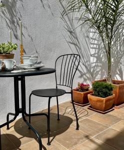 une table et une chaise noires et quelques plantes en pot dans l'établissement Casa da Lapa, à Lisbonne 8 autres photos