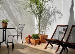 un patio avec une table, des chaises et des plantes en pot dans l'établissement Casa da Lapa, à Lisbonne
