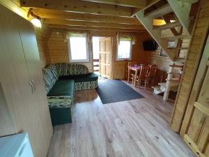 a living room with a couch in a log cabin at Domki Noclegowe 693-664-683 in Solina