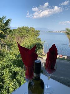 uma garrafa de vinho e um copo de vinho com flores vermelhas em La Dolce Vita em Meina