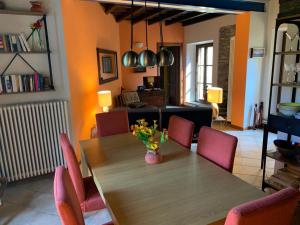 uma sala de jantar com uma mesa de madeira e cadeiras cor-de-rosa em La Dolce Vita em Meina