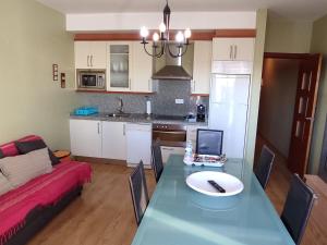 a living room and kitchen with a table with a laptop at Calle Ancla Isla Cristina in Isla Cristina