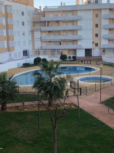 two swimming pools in a park with a building at Calle Ancla Isla Cristina in Isla Cristina +2 photos