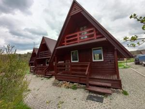 a log cabin with a gambrel roof at Domki Noclegowe 693-664-683 in Solina