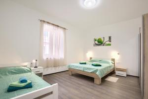 a white bedroom with two beds and a mirror at Amphitheater 3+2 modern apartment with terrace, WiFi, Netflix in Pula