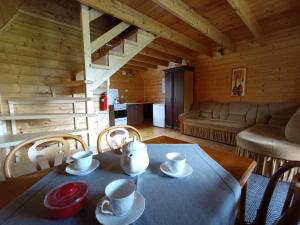 a table with cups and saucers on it in a living room at Domki Noclegowe 693-664-683 in Solina