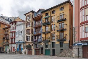 una fila de edificios coloridos en una ciudad en La Casita del pescador By Kabia Gestión, en Bermeo