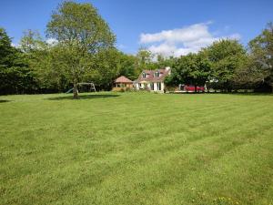 a large grass field with a house in the background at Little Fisher Farm - Farm-View Retreat in Chichester