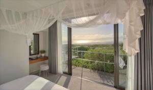 a bedroom with a bed and a large window at Grootbos Private Nature Reserve in Gansbaai