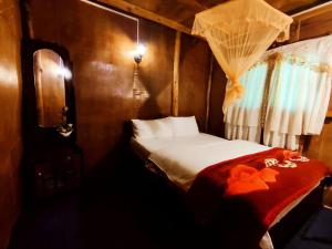 a small bedroom with a bed with a red blanket at Moon Plains Forest Log in Nuwara Eliya