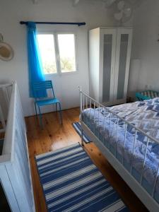 エギオにあるSpiti Ostriaのベッドルーム1室(ベッド1台、青い椅子付)