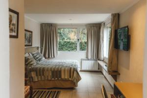 un dormitorio con una cama y una ventana en Departamentos De la Plaza, en Villa La Angostura