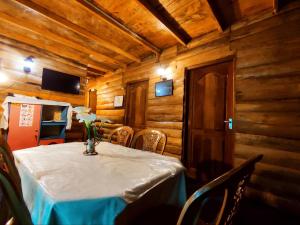 a dining room with a table with a vase of flowers on it at Moon Plains Forest Log in Nuwara Eliya