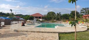 uma piscina num resort com pessoas sentadas à sua volta em rancho durian hotel y restaurante em Las Galeras