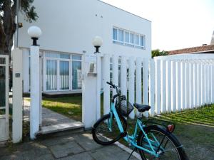 una bici blu parcheggiata accanto a una recinzione di Villa Marina a Lido di Venezia