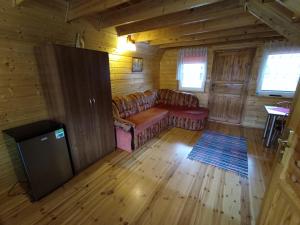 a living room with a couch in a cabin at Domki Noclegowe 693-664-683 in Solina