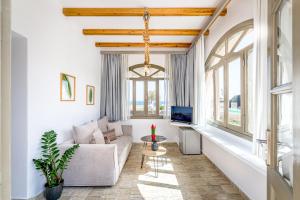 a living room with a couch and a tv at En Plo Boutique Suites in Oia
