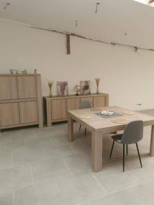 um quarto com mesa, cadeiras e armários em Le caillou Blanc em Charleroi