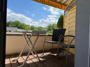 eine Veranda mit 2 Stühlen und einem Tisch auf dem Balkon in der Unterkunft Parkhotel Crombach in Rosenheim