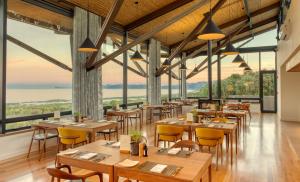 a restaurant with wooden tables and chairs and large windows at Grootbos Private Nature Reserve in Gansbaai