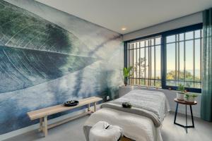 a bedroom with a bed and a large leaf mural at Grootbos Private Nature Reserve in Gansbaai