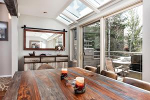 a dining room with a wooden table and a large window at Villa's of Aspen by Snowmass Vacations in Aspen