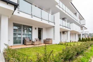 a view of a house with a patio and grass at Flatbook Apartamenty - Sztutowo Baltic Sun -A- z Basenem in Sztutowo +22 photos