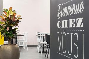 een eetkamer met een bord met een duurzaam stadsbezoek bij B&B HOTEL Liège Rocourt in Luik