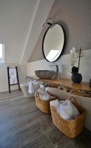baño con lavabo, espejo y cestas en GALIHOST - Casa Esclavi, en Cambados
